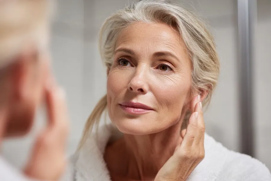 mature woman looking at herself in the mirror